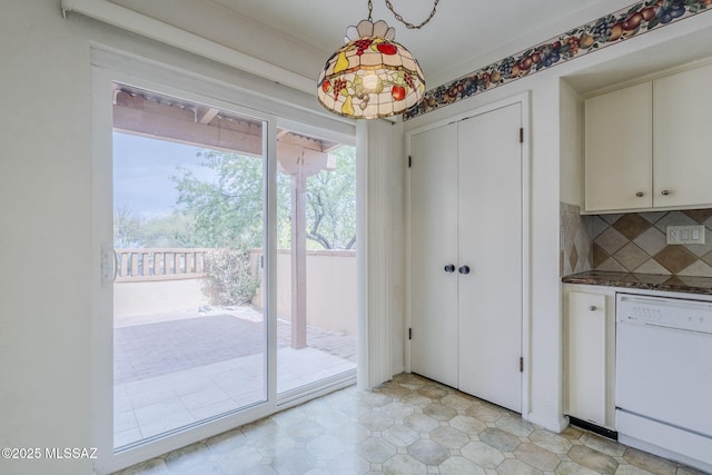 interior space featuring dark countertops, hanging light fixtures, dishwasher, and tasteful backsplash