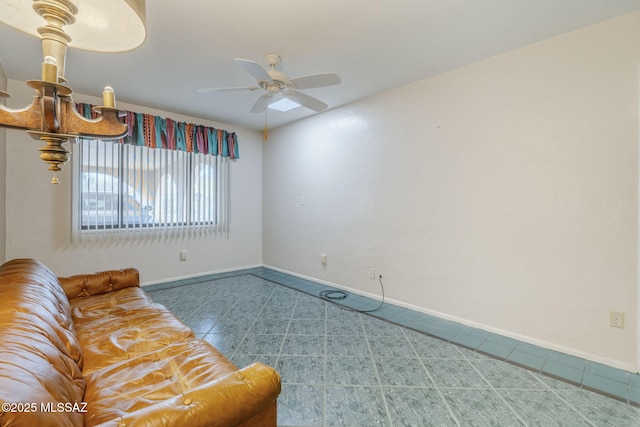 tiled living area with ceiling fan and baseboards