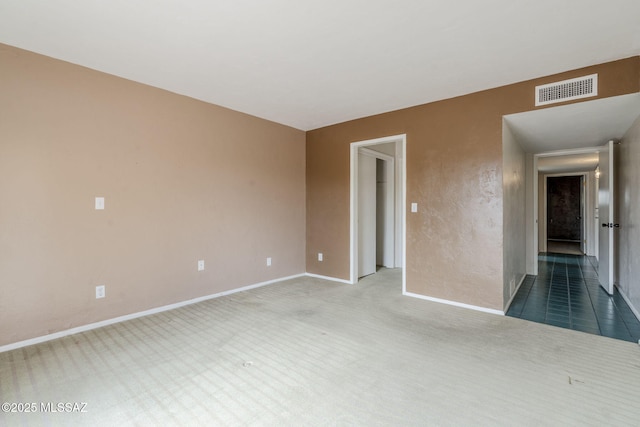 unfurnished room featuring carpet flooring, visible vents, and baseboards