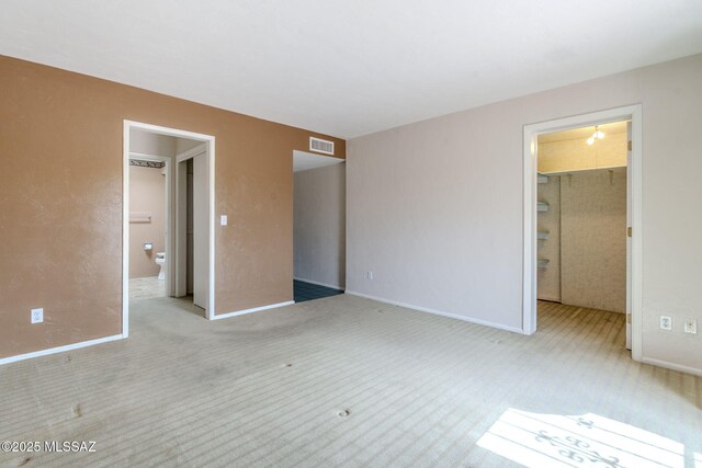 unfurnished bedroom featuring visible vents, a spacious closet, carpet floors, and a closet
