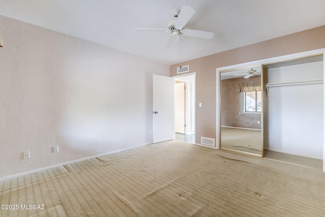 unfurnished bedroom with a closet, visible vents, ceiling fan, and carpet