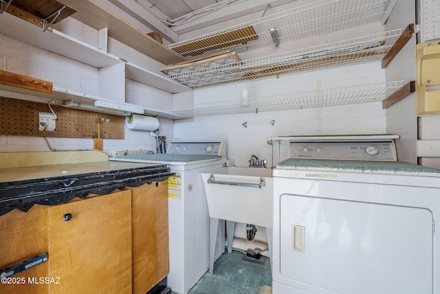 washroom with a sink, independent washer and dryer, and laundry area