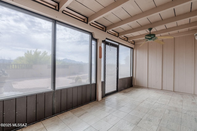 unfurnished sunroom with beamed ceiling and a ceiling fan