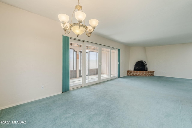 unfurnished living room featuring a chandelier, carpet floors, and a brick fireplace