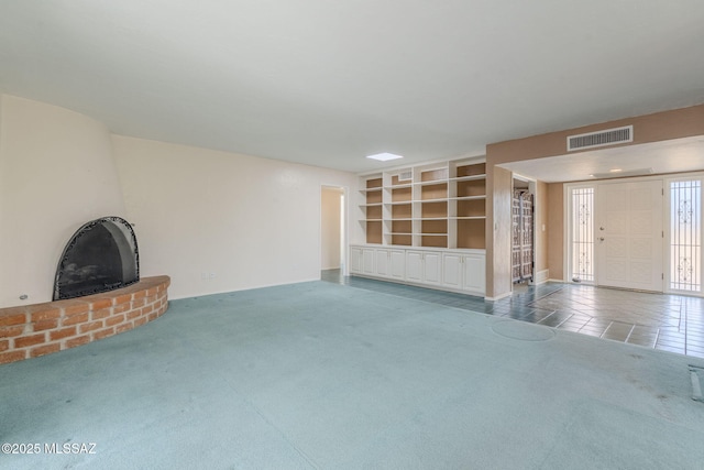 unfurnished living room with carpet, visible vents, and built in features