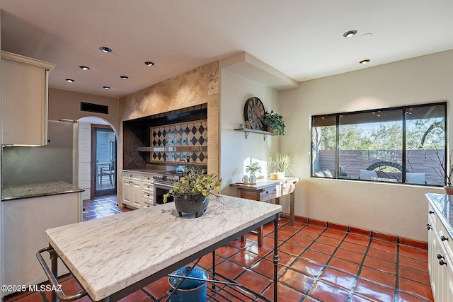 4401 E Havasu Rd, Tucson, AZ 85718 - kitchen with arched walkways, visible vents, white cabinets, recessed lighting, and gas range