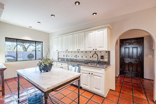 4401 E Havasu Rd, Tucson, AZ 85718 - kitchen with arched walkways, dishwasher, a sink, white cabinetry, and backsplash