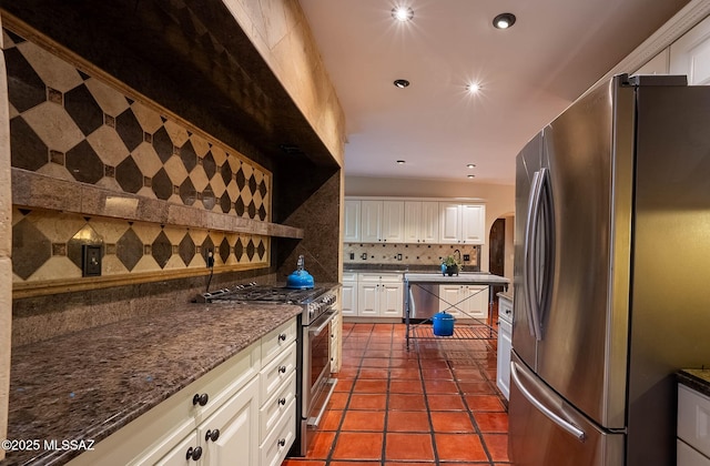 4401 E Havasu Rd, Tucson, AZ 85718 - kitchen featuring tasteful backsplash, dark tile patterned floors, white cabinetry, and appliances with stainless steel finishes