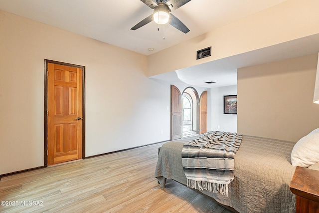 4401 E Havasu Rd, Tucson, AZ 85718 - bedroom with light wood-type flooring, arched walkways, a ceiling fan, visible vents, and baseboards