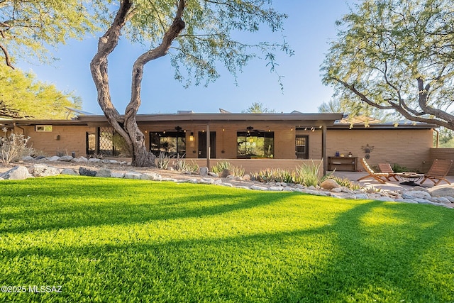 4401 E Havasu Rd, Tucson, AZ 85718 - rear view of house featuring an outdoor fire pit, a patio area, ceiling fan, and a lawn