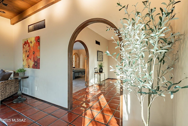 4401 E Havasu Rd, Tucson, AZ 85718 - hall featuring visible vents, wooden ceiling, arched walkways, tile patterned floors, and vaulted ceiling with beams
