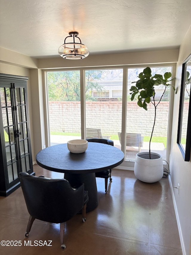 dining space featuring concrete flooring and baseboards