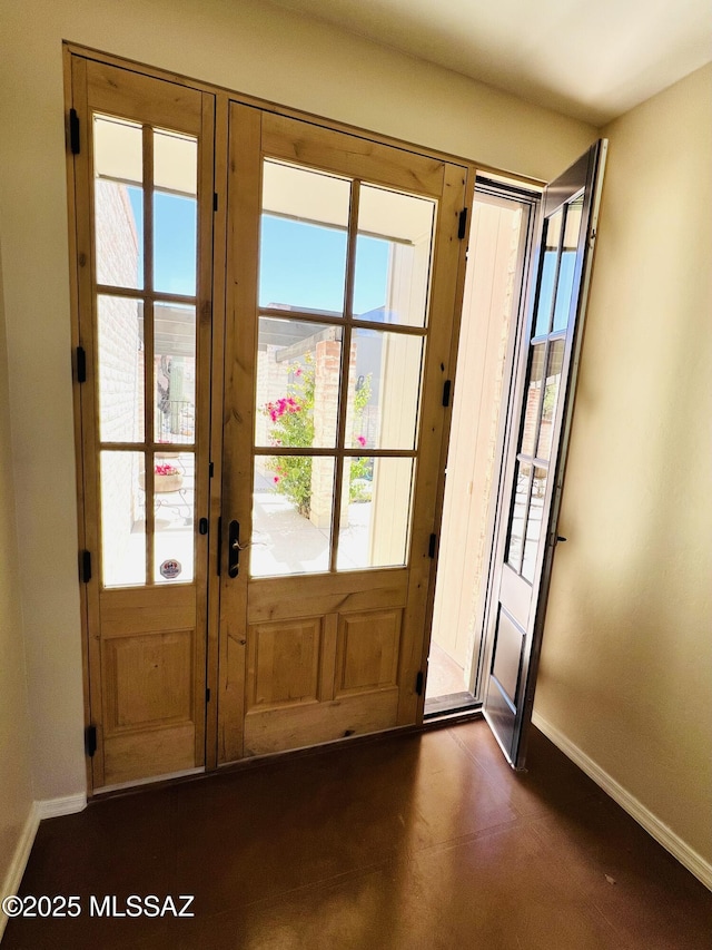 doorway to outside featuring french doors and baseboards