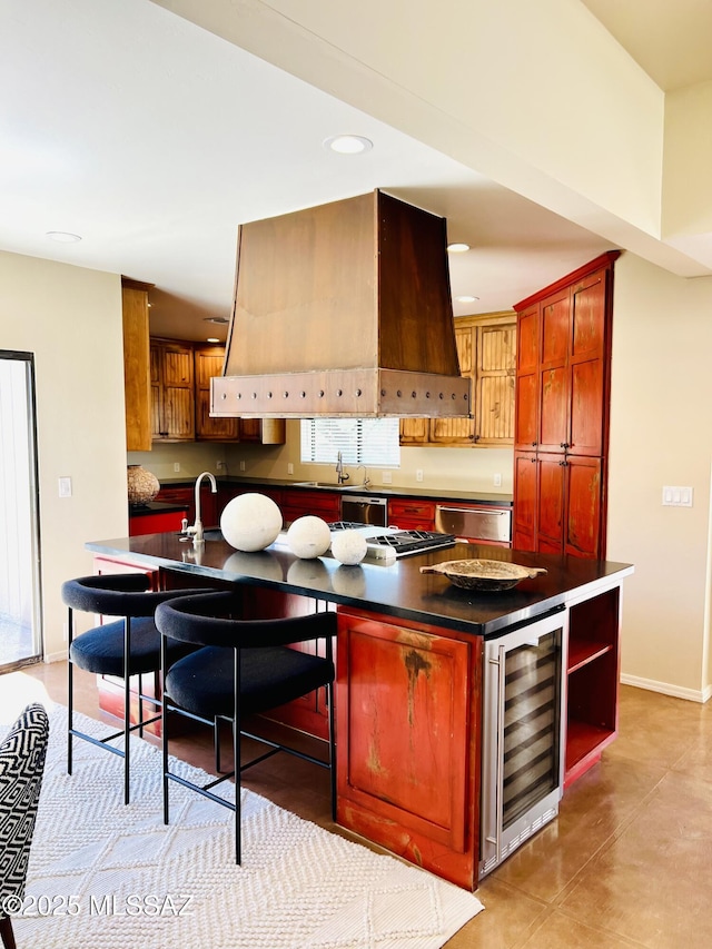 kitchen with dishwasher, dark countertops, beverage cooler, and a center island with sink