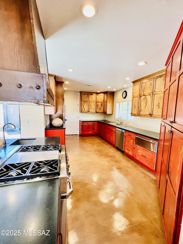 kitchen with stainless steel appliances, a sink, a warming drawer, recessed lighting, and concrete flooring