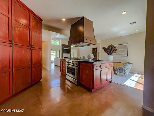 kitchen featuring high end stove, visible vents, a sink, finished concrete flooring, and custom exhaust hood