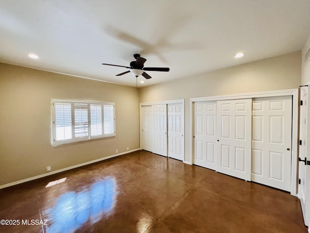 unfurnished bedroom with baseboards, recessed lighting, finished concrete flooring, ceiling fan, and two closets