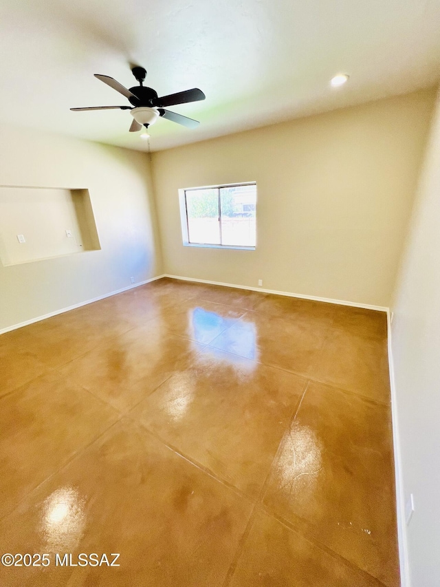 unfurnished room featuring concrete flooring, baseboards, and ceiling fan
