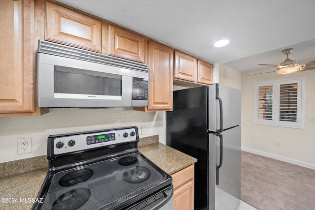 kitchen with carpet floors, baseboards, light brown cabinetry, and stainless steel appliances
