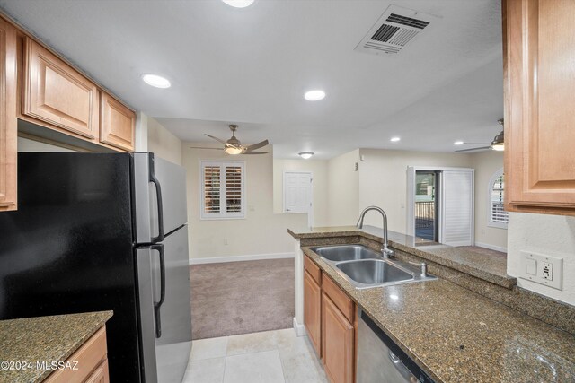 kitchen with a sink, freestanding refrigerator, ceiling fan, and visible vents