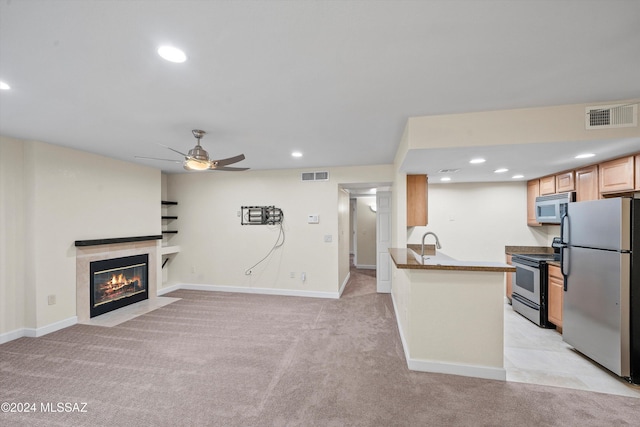kitchen with dark countertops, visible vents, appliances with stainless steel finishes, and light colored carpet