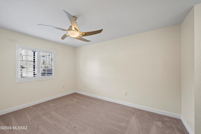 carpeted spare room with baseboards and ceiling fan