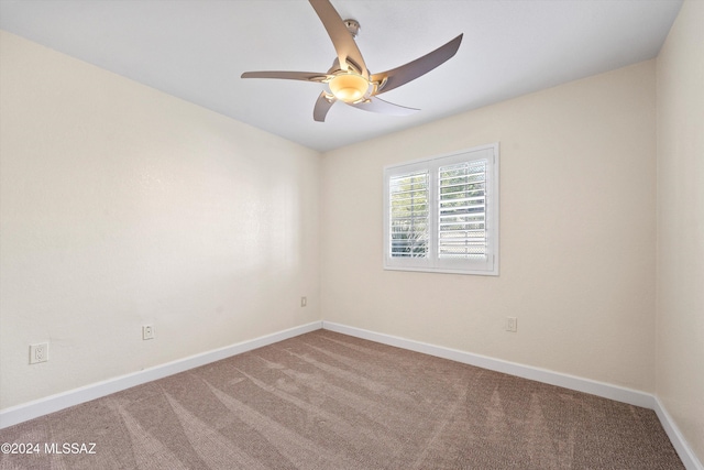 carpeted empty room with baseboards and a ceiling fan