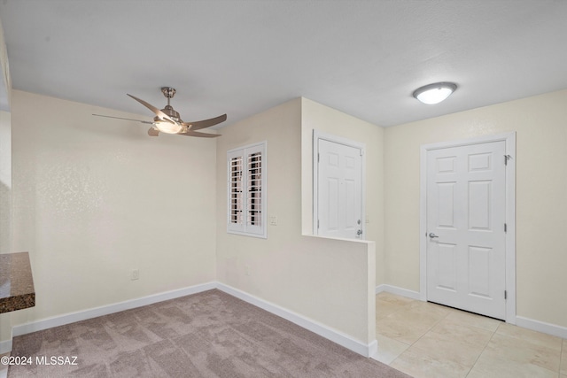 unfurnished room with ceiling fan, light tile patterned flooring, and baseboards