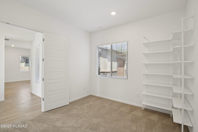 unfurnished bedroom featuring baseboards, recessed lighting, and carpet