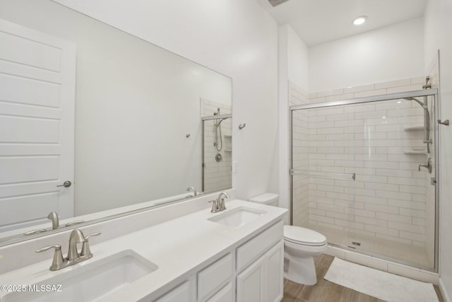 full bathroom featuring a sink, toilet, and a shower stall