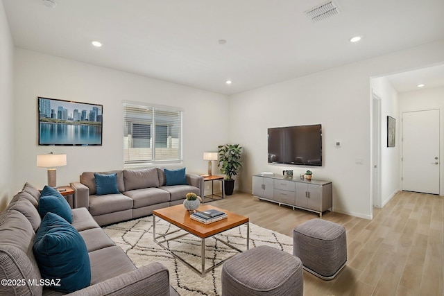 living area featuring visible vents, light wood-style flooring, and recessed lighting