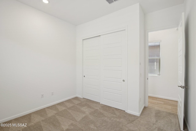 unfurnished bedroom featuring a closet, carpet flooring, baseboards, and visible vents