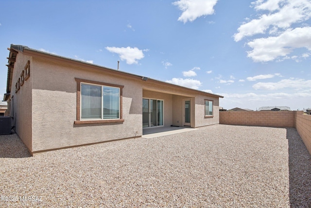 back of house featuring a patio, stucco siding, a fenced backyard, and central AC