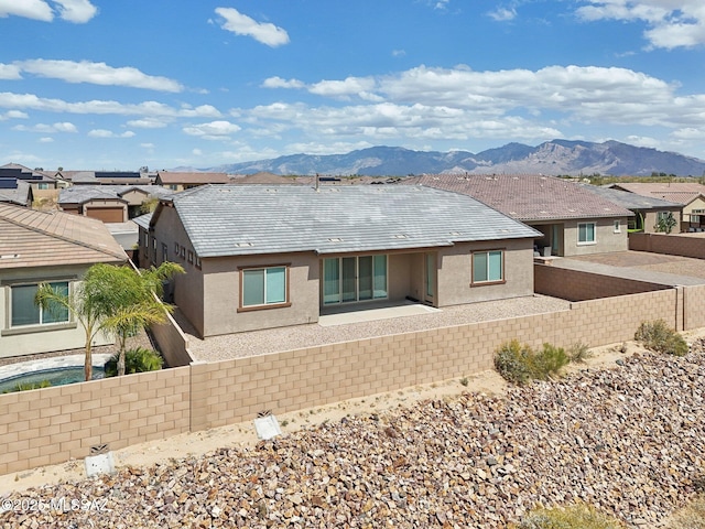 back of property featuring fence, a residential view, stucco siding, and a mountain view