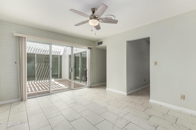 empty room with marble finish floor, visible vents, a ceiling fan, and baseboards