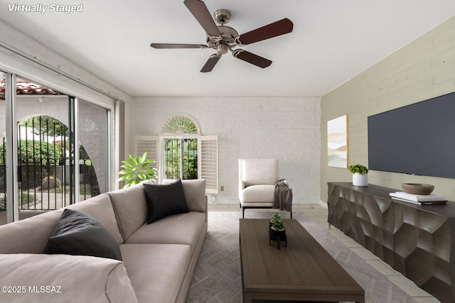 tiled living room with brick wall and a ceiling fan