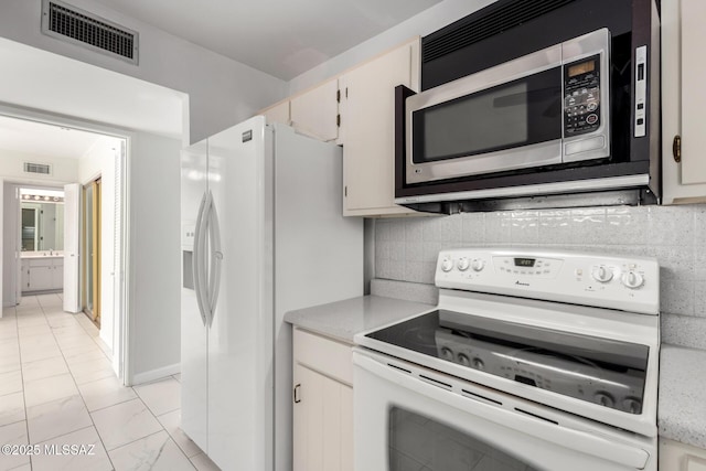 kitchen featuring visible vents, decorative backsplash, white appliances, marble finish floor, and light countertops
