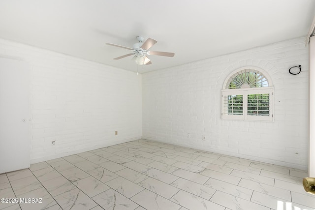 empty room with marble finish floor and a ceiling fan