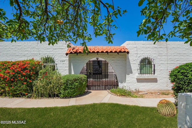 view of front of house featuring a gate and a tiled roof