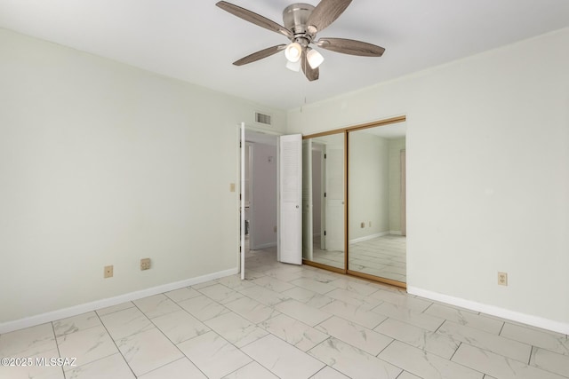 unfurnished bedroom with a closet, visible vents, marble finish floor, and baseboards