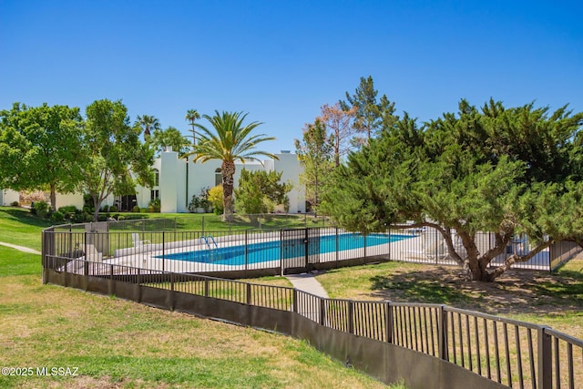 community pool with fence and a yard