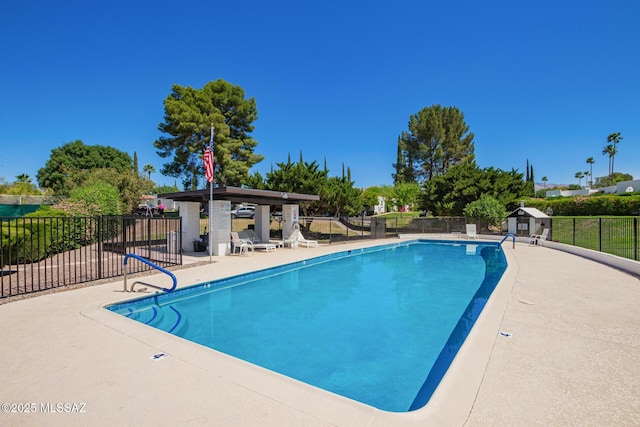 pool with a patio area and fence