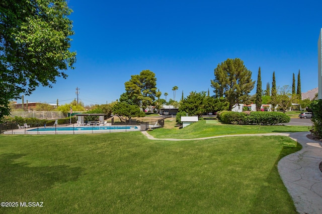 exterior space featuring a lawn, fence, and a swimming pool