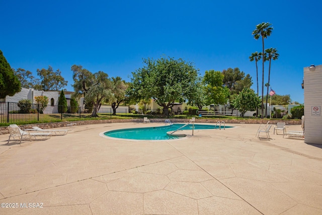 pool featuring fence and a patio