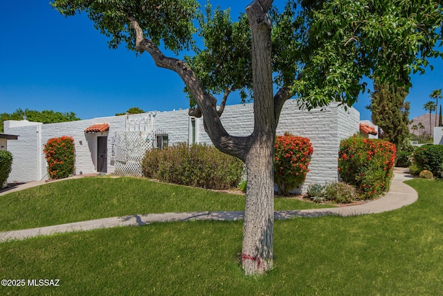 view of side of home with a lawn