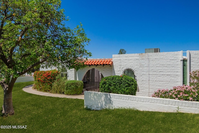 view of front facade featuring a tile roof and a front lawn