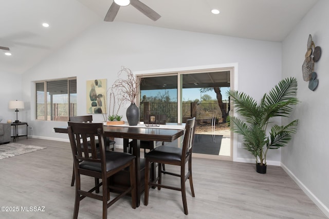 dining room featuring baseboards, ceiling fan, light wood finished floors, and lofted ceiling