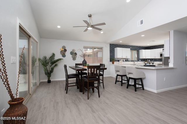 dining space with visible vents, lofted ceiling, recessed lighting, light wood-type flooring, and a ceiling fan