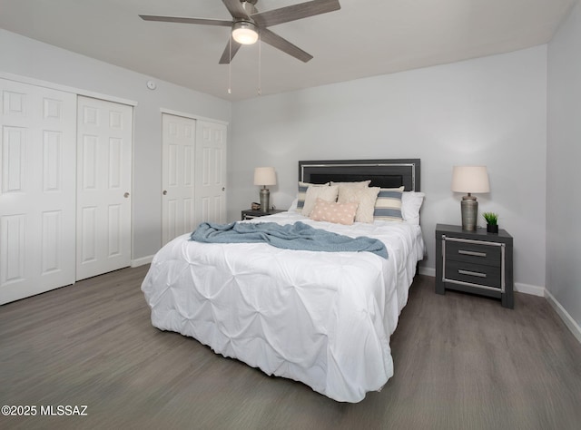 bedroom featuring baseboards, ceiling fan, two closets, and wood finished floors