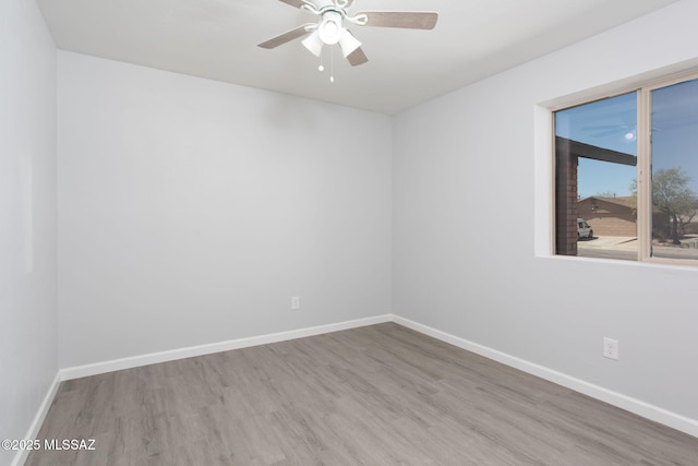 empty room with baseboards, ceiling fan, and wood finished floors